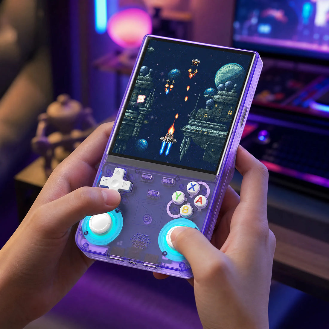 Console portable rétrogaming 4 pouces tenue en main en pleine partie, ambiance gaming néon bleu et violet.